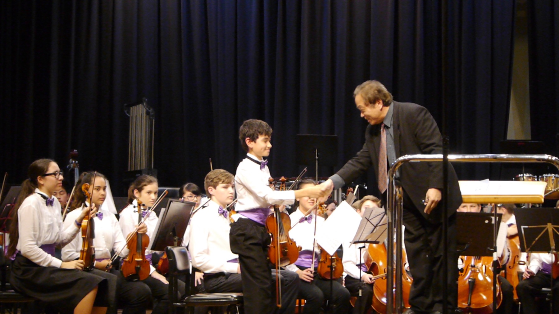 Student concertmaster performing with orchestra