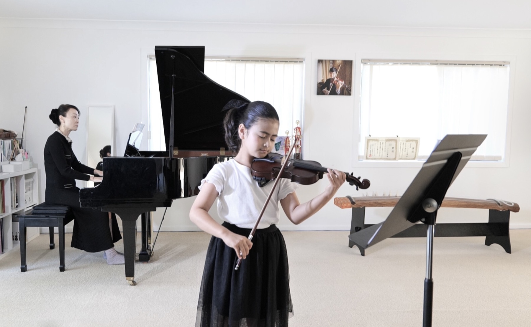 Young violin student performing with piano accompaniment