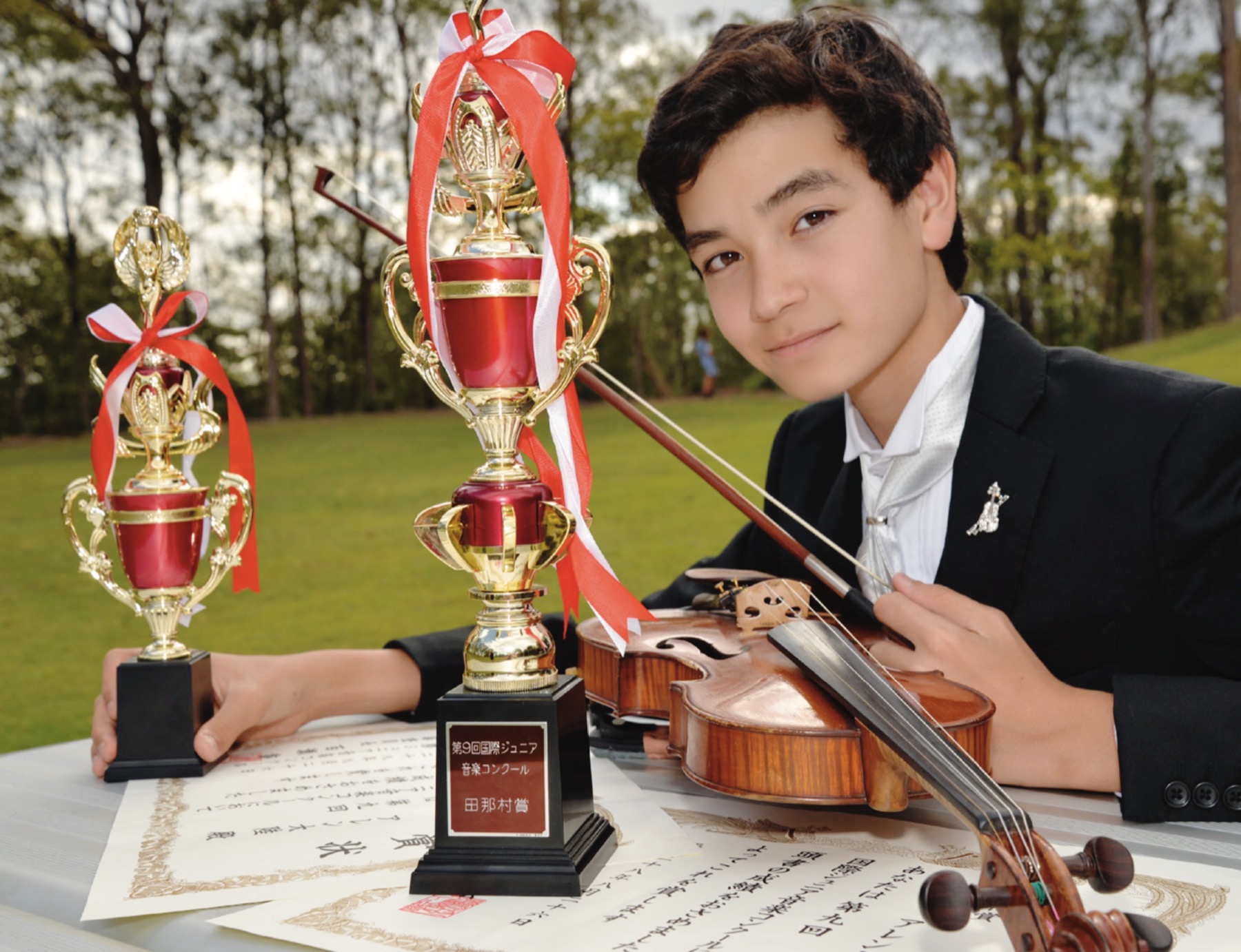 Student with violin and competition trophies